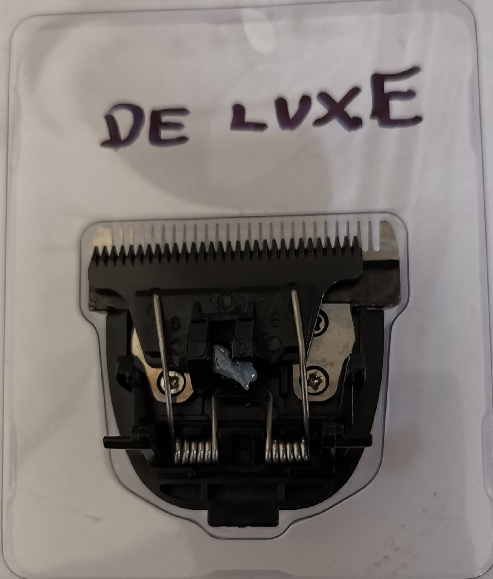 Läpinäkyvässä paketissa iClipper De Luxe merkkisen trimmauskoneen varaterä, takaosa kuvattuna